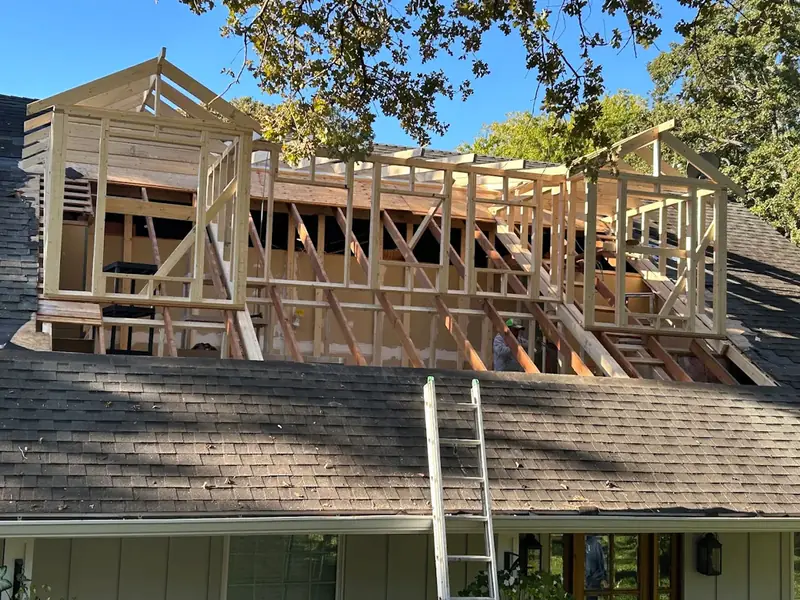 Upper-story wall framing above an existing roof
