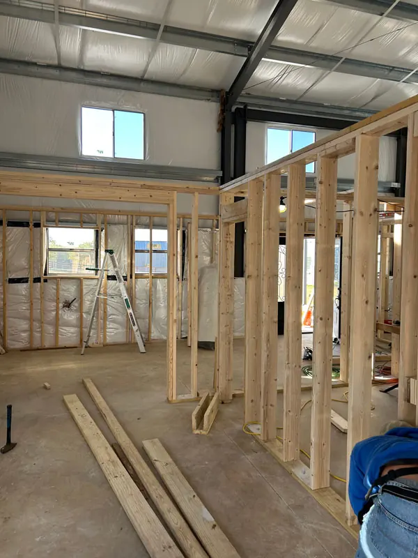 Interior wood wall framing beneath a metal building roof